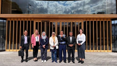 Regional Development Manager and the Accountant General of Malaysia’s team standing outside the Blavatnik School of Government in the sunshine, smiling at the camera.